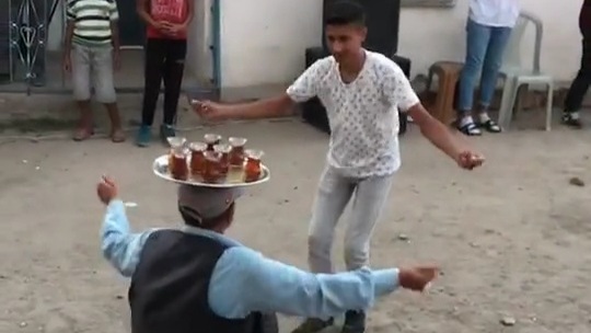 Başında çay tepsisi ile oyun oynayan dayı